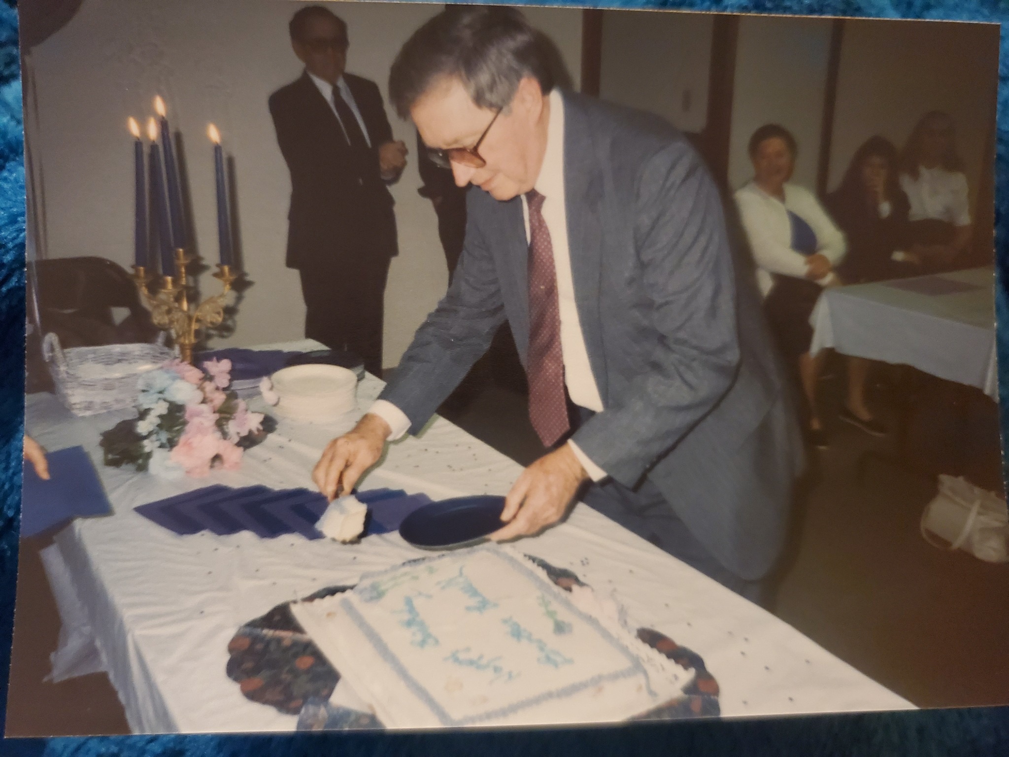 Russell cutting a cake at a gathering